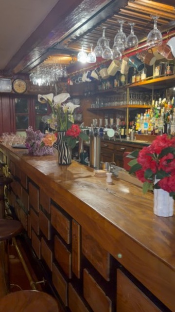 Le bar du restaurant Le Goëland, verres suspendus et fleurs