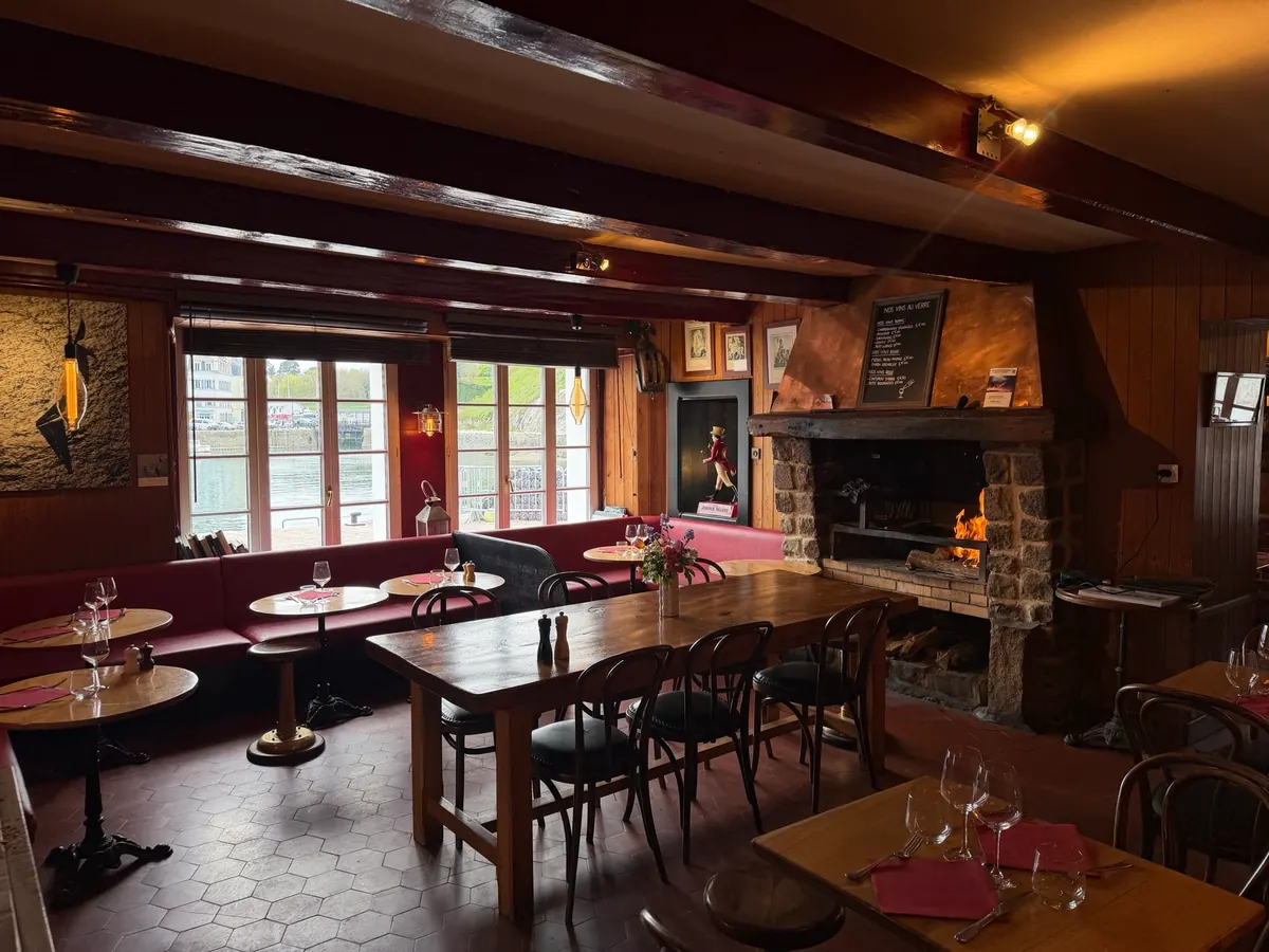 Salle du restaurant Le Goéland avec cheminée et vue sur le port